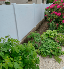 Clôture Initiale de teinte blanche avec des fleurs devant